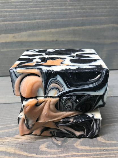 a photo of animal instinct soap with striking white and black sections with orange accents