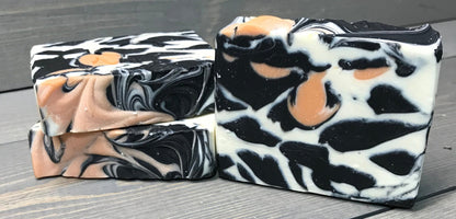 a photo of animal instinct soap with striking white and black sections with orange accents