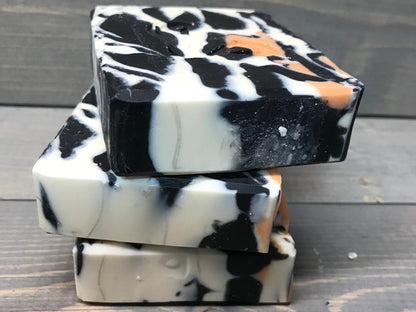 a photo of animal instinct soap with striking white and black sections with orange accents