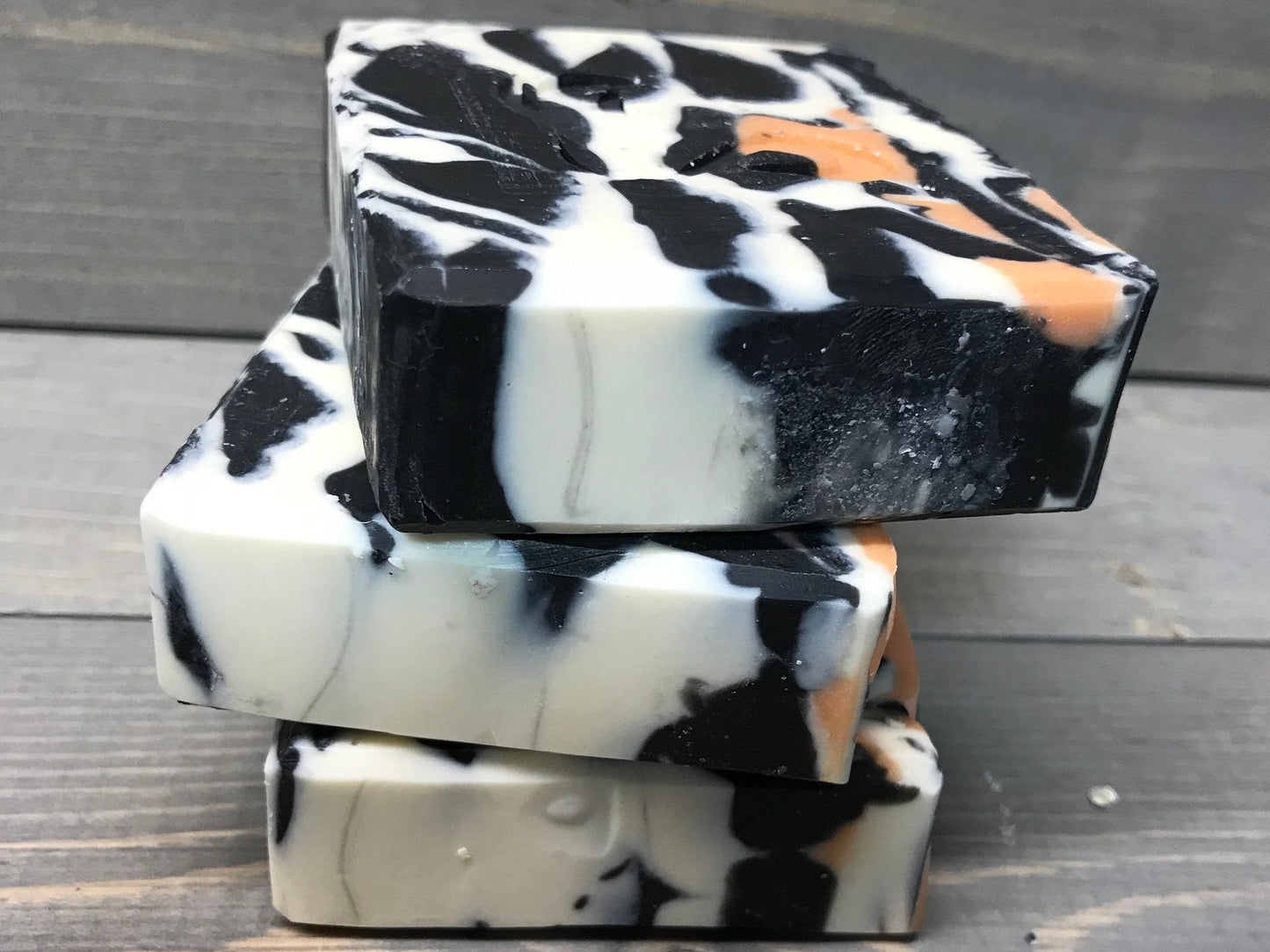 a photo of animal instinct soap with striking white and black sections with orange accents