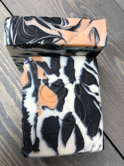 a photo of animal instinct soap with striking white and black sections with orange accents