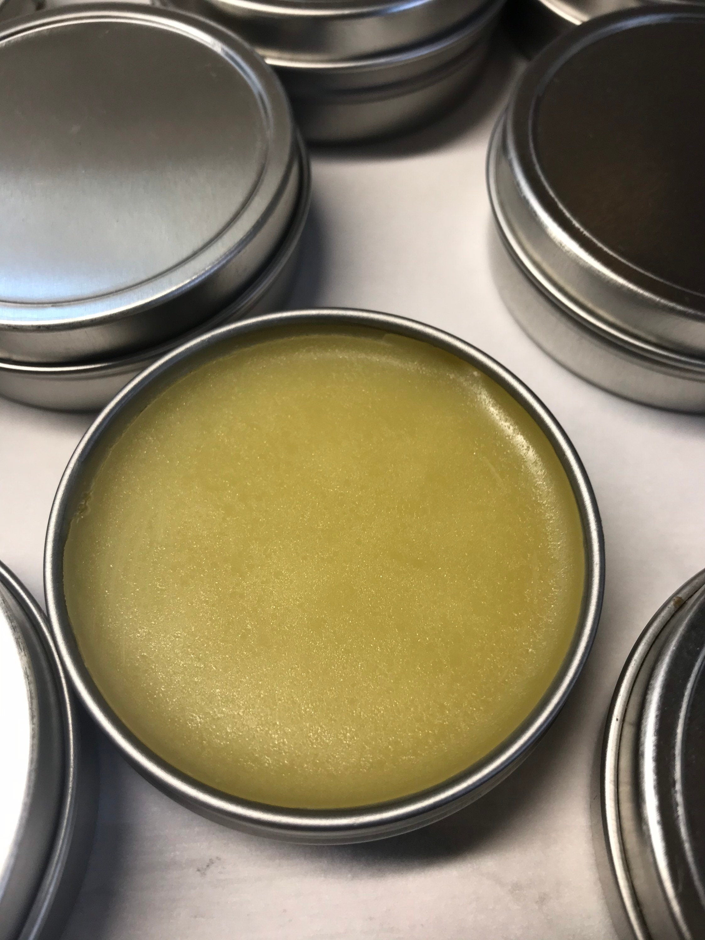 A photo showing a container of Cut and Abrasion Salve