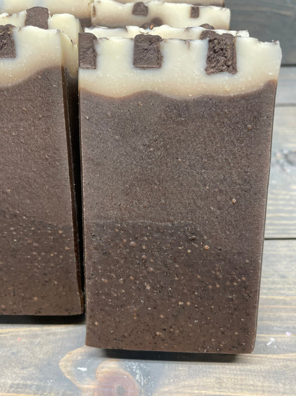 a photo of Breakfast Coffee soap, Oatmeal and Coffee Soap with a brown base, topped in a cream color and has coffee soap adornments