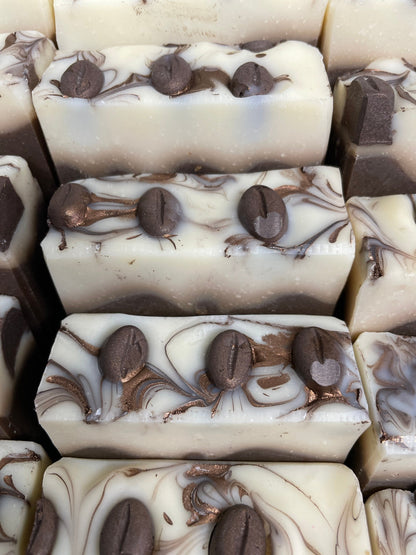 a photo of Breakfast Coffee soap, Oatmeal and Coffee Soap with a brown base, topped in a cream color and has coffee soap adornments