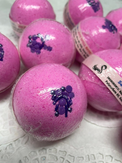 a photo of several Love Spell flower and fruit scented Bath Bombs, Love Spell with Embeds in pink with purple accents