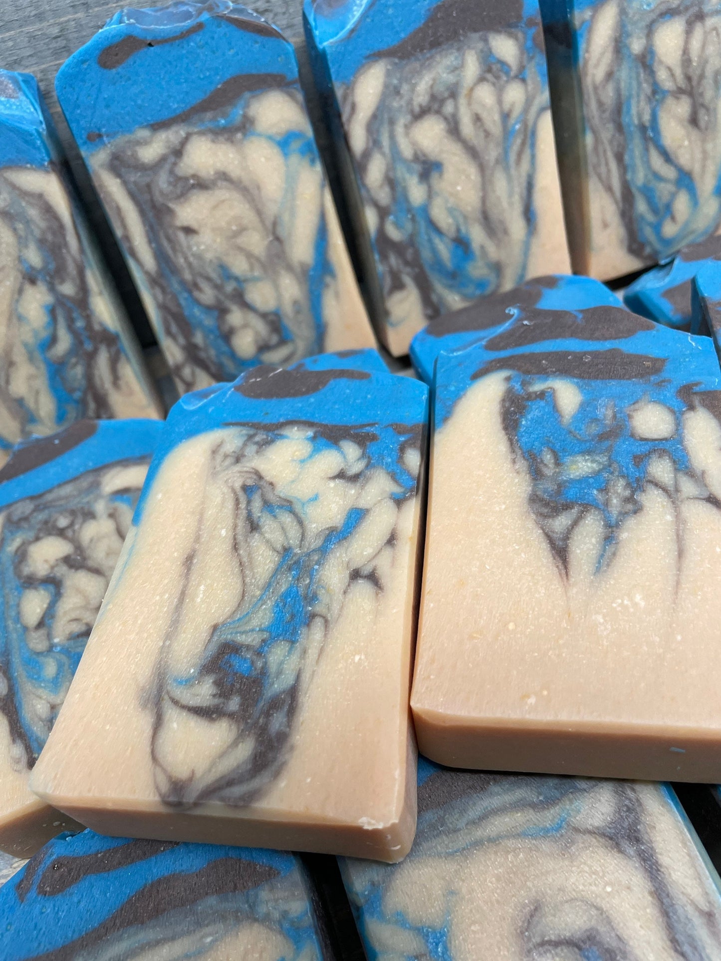 A photo of Beachwood Vetiver Goat Milk Soap with light blue and gray accent of a creamy color bar