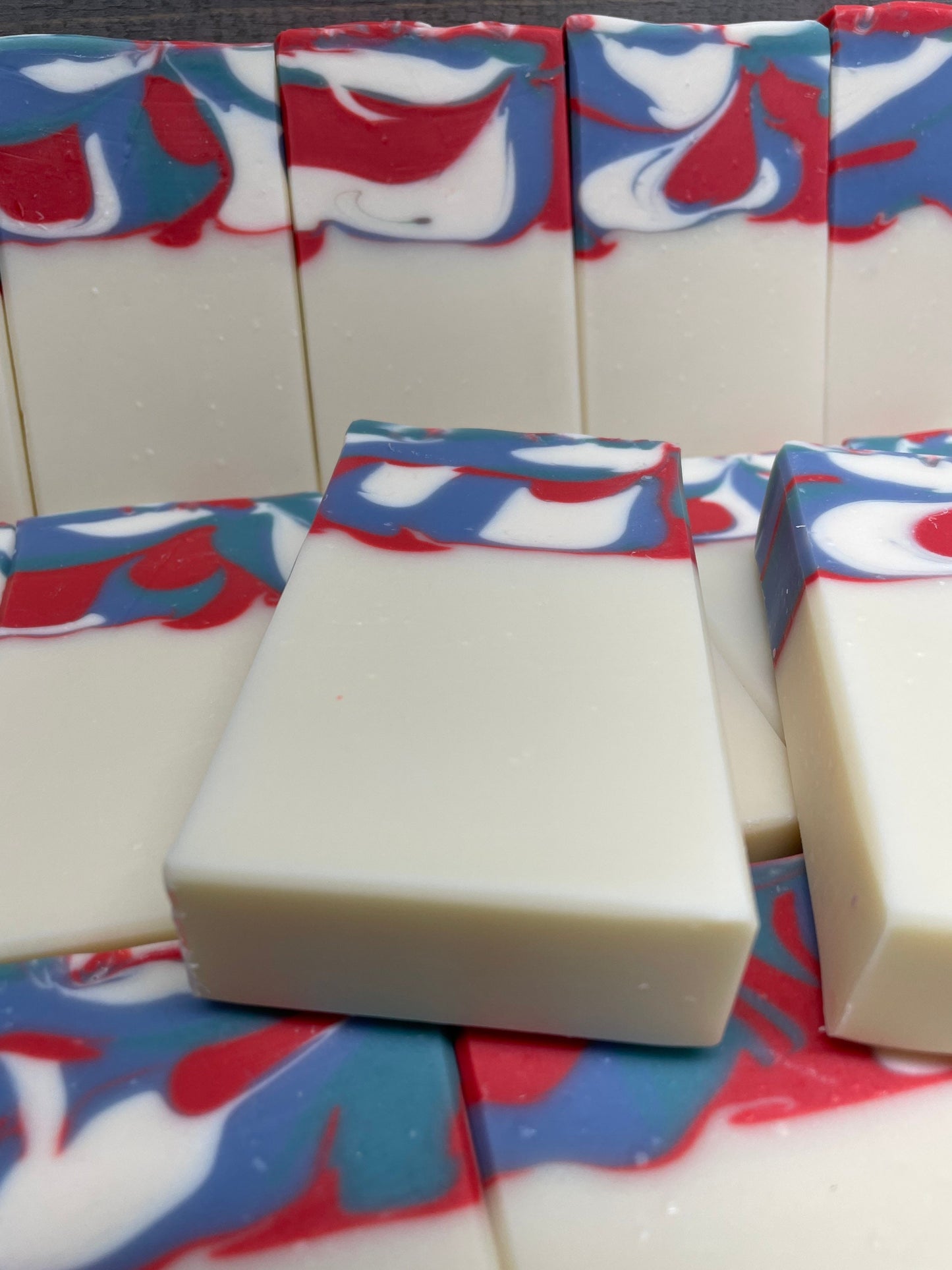 A photo of Garden Mint Soap topped with a swirl of red, white, and blue. 