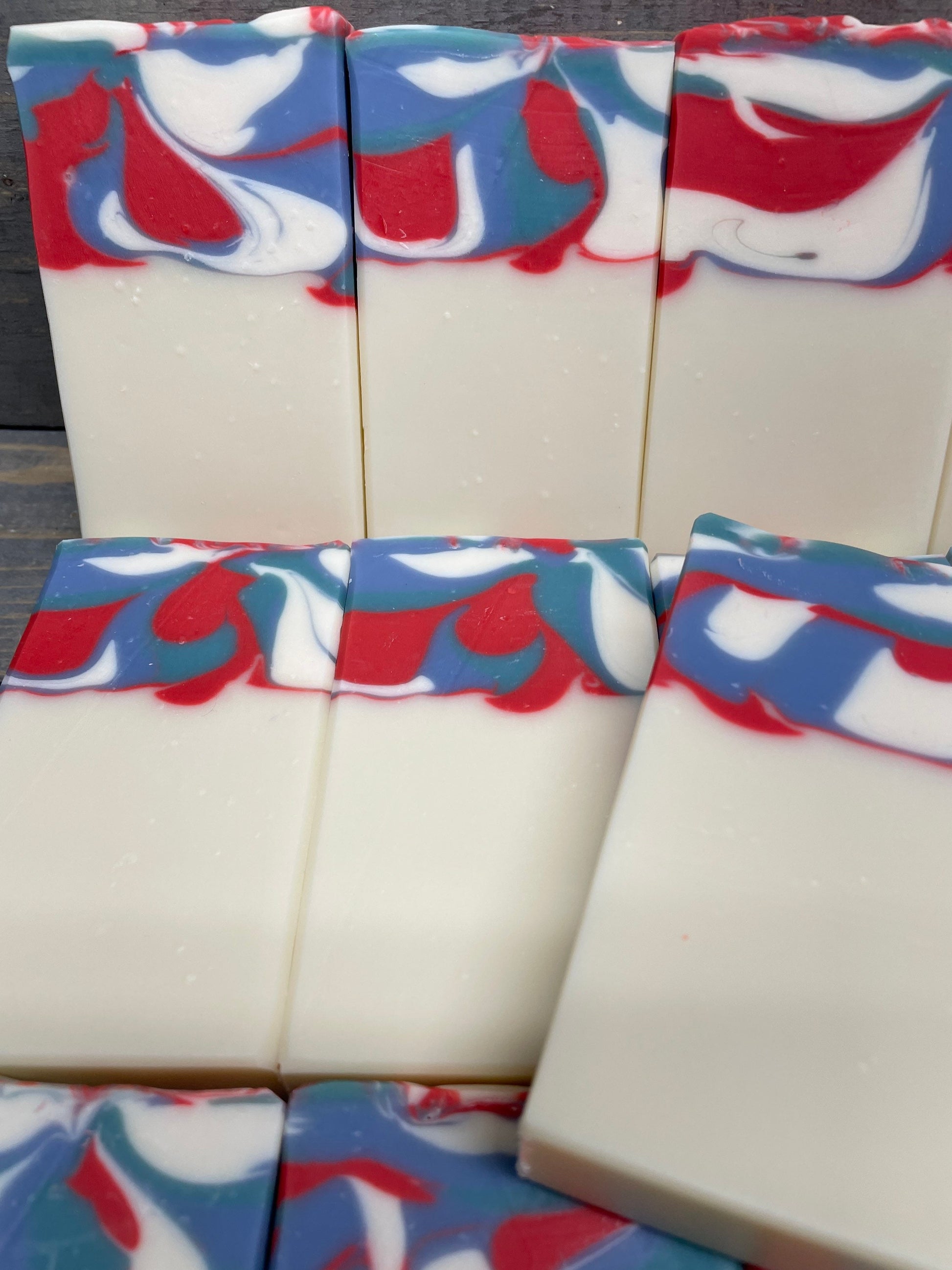 A photo of Garden Mint Soap topped with a swirl of red, white, and blue. 