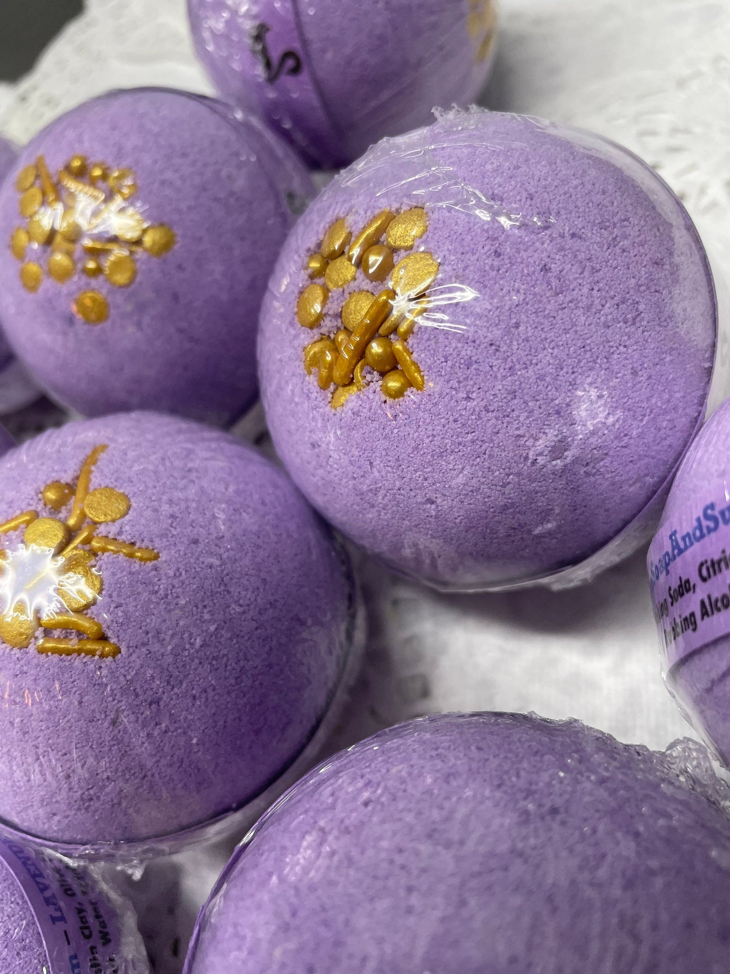 a photo of Lavender Bath Bombs with Embeds of colors topped with gold sugar sprinkles in lavender pastel colors