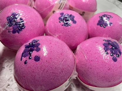 a photo of several Love Spell flower and fruit scented Bath Bombs, Love Spell with Embeds in pink with purple accents