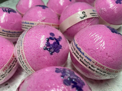 a photo of several Love Spell flower and fruit scented Bath Bombs, Love Spell with Embeds in pink with purple accents