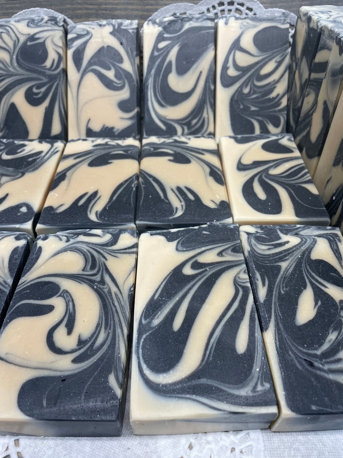 A photo of Goat Milk and Charcoal Soap bar soap swirled with black and cream colored bars. 
