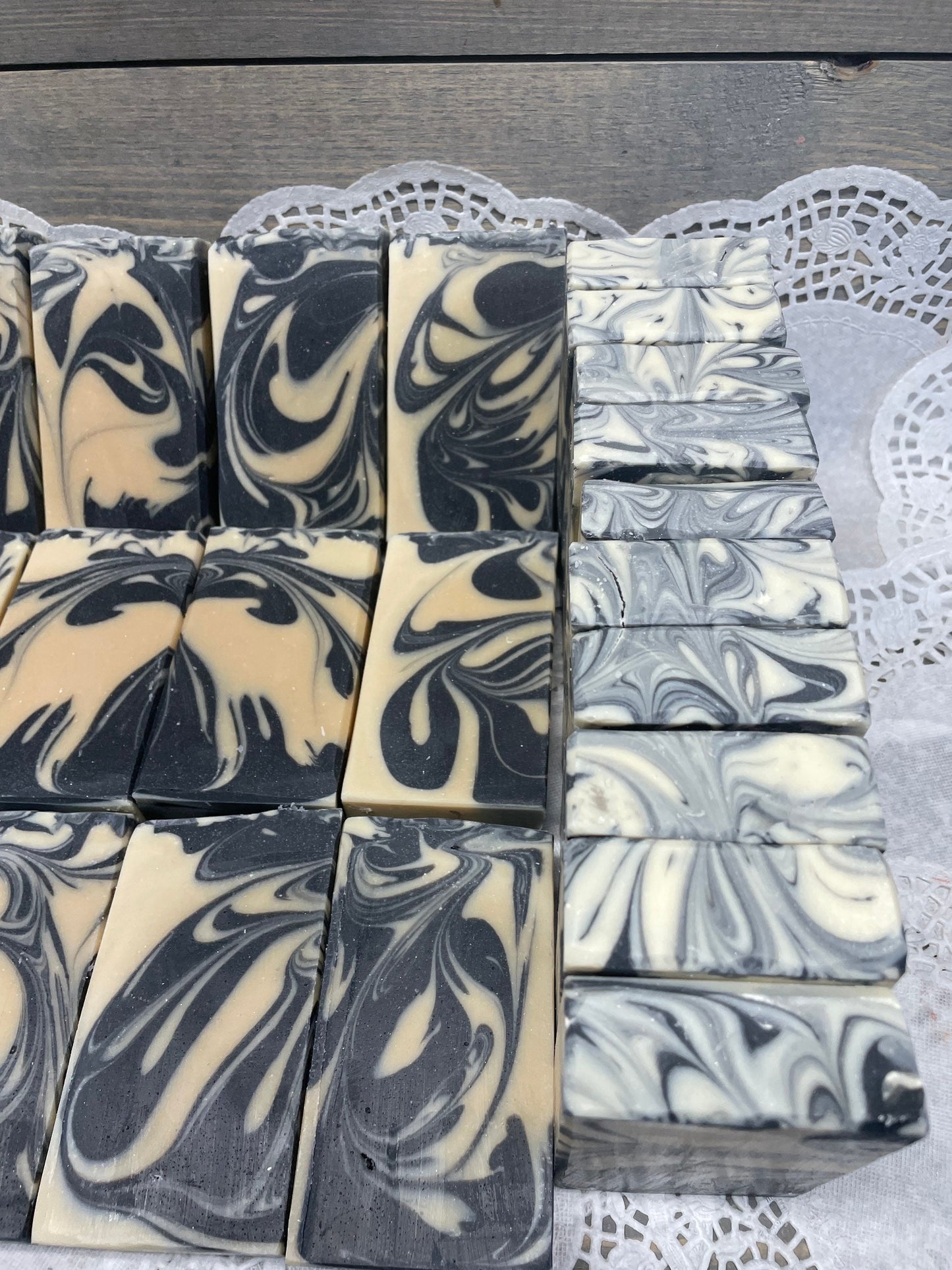 A photo of Goat Milk and Charcoal Soap bar soap with black and cream colored bars. 