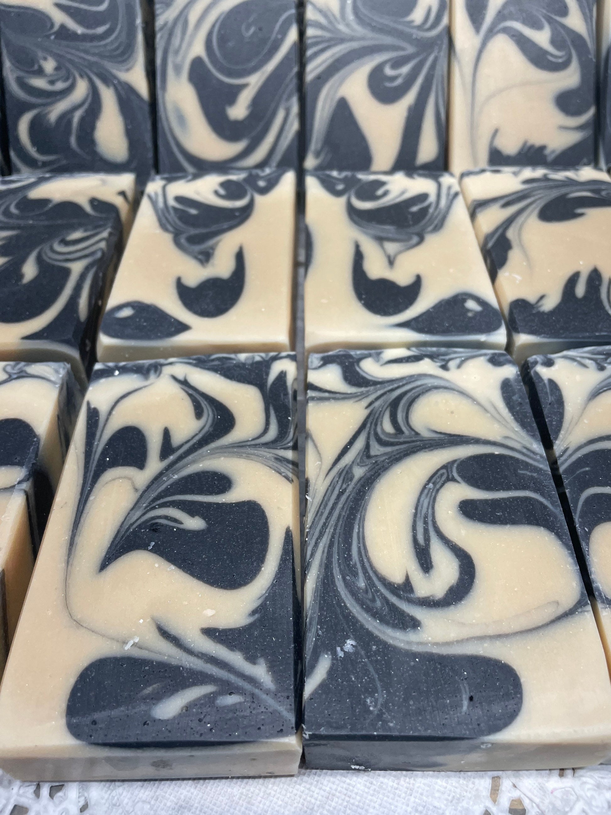 A photo of Goat Milk and Charcoal Soap bar soap swirled with black and cream colored bars. 