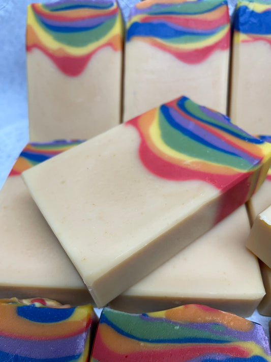 A photo of Hobo Bamboo Goat Milk Soap with Patchouli and Lemongrass Essential Oils of a cream color base with a layered rainbow top