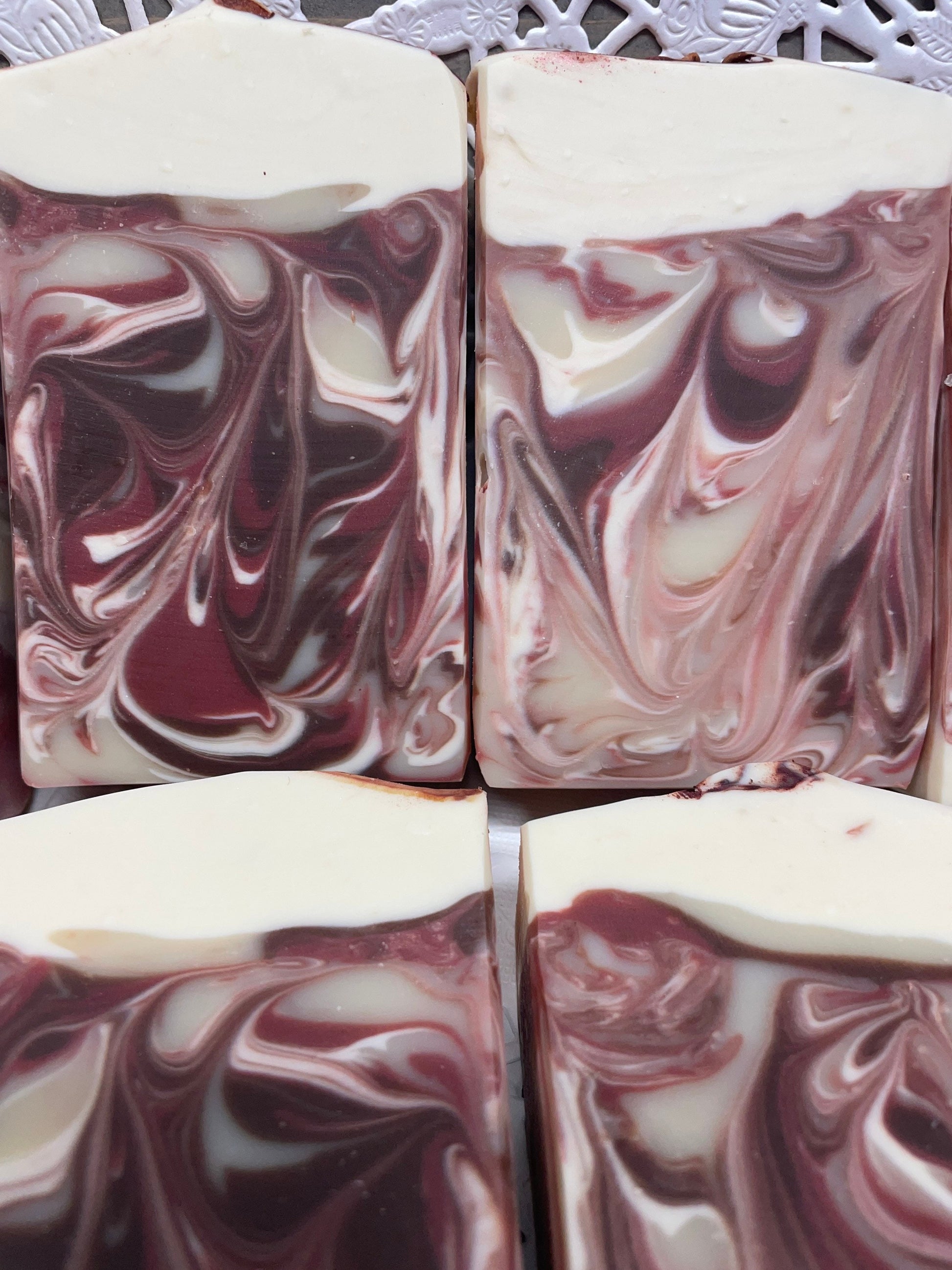 A photo of Apple Dumpling Soap with maroon color and topped in cream color